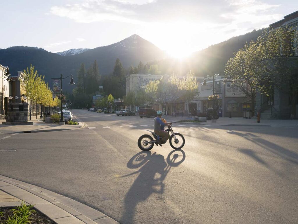 Dad And Child On A Dirtbike In Town.