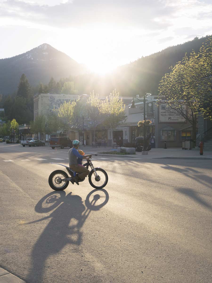 Dad And Child On A Dirtbike In Town.
